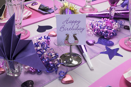 粉色和紫色主题餐桌设置装饰品生日快乐信背景图片