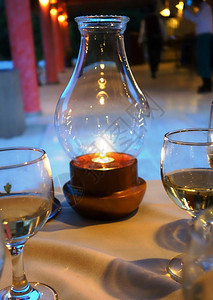 台灯上的蜡烛和带饮料的酒杯摆在桌子上图片