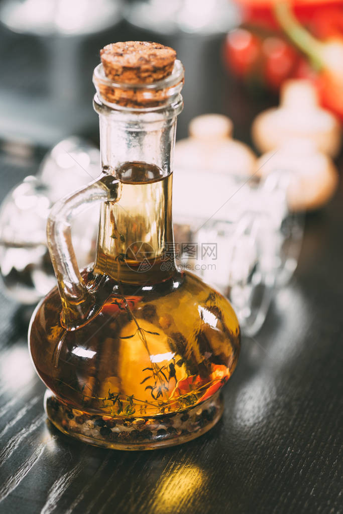 玻璃瓶中带有香料的橄榄油的特写视图图片