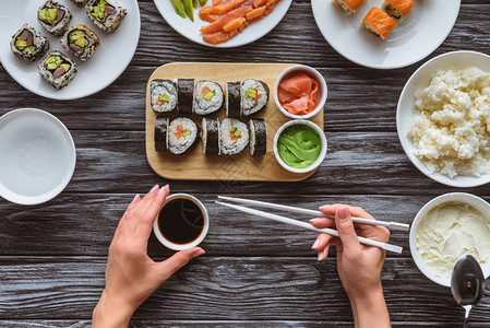 拿着筷子吃美味寿司的人裁剪镜头图片