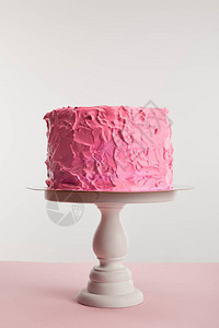 在蛋糕架上的粉红色甜生日蛋糕与灰色隔离图片