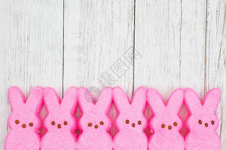 粉红糖果小兔子在风湿白洗的木质纹纸木背景上图片