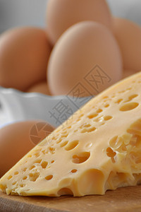 白盘中的鸡蛋和木桌上的奶酪图片