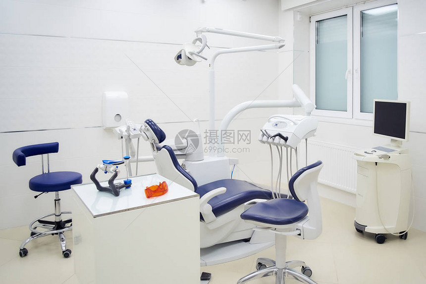 牙科诊所的新内部配有白色和蓝色家具牙科椅口腔内扫描仪图片