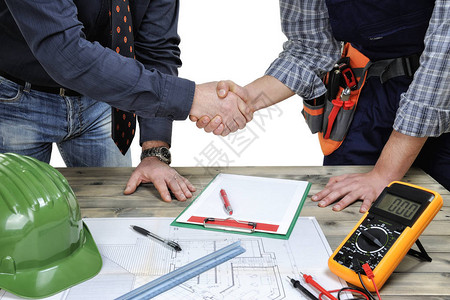 工程师和技术工在古董木制桌子上对一栋住宅楼的图片