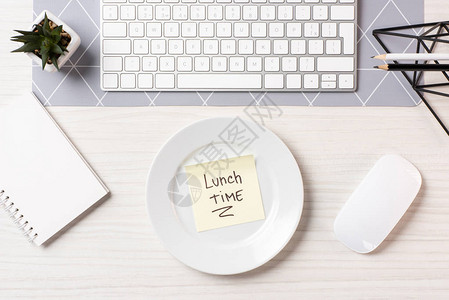 将午餐时间刻在餐盘计算机鼠标和工作场所键盘图片