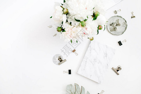 平躺式家庭办公桌女工作区与白牡丹花束配饰白色背景的大理石日记顶图片