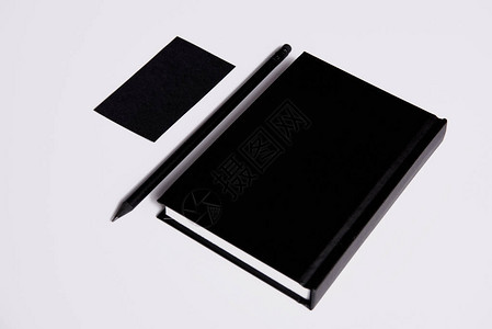 黑色笔记本用铅笔和名片在白色表面用背景图片