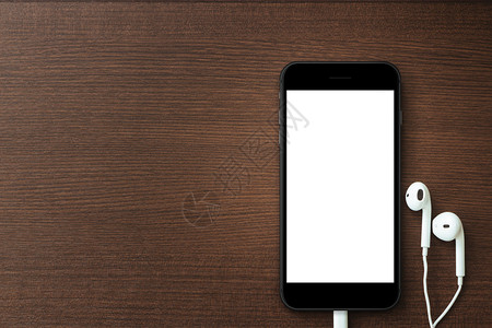 手机空白屏幕和木板上的耳机模图片