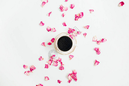 白色背景的咖啡和粉红玫瑰花瓣平坦的躺图片
