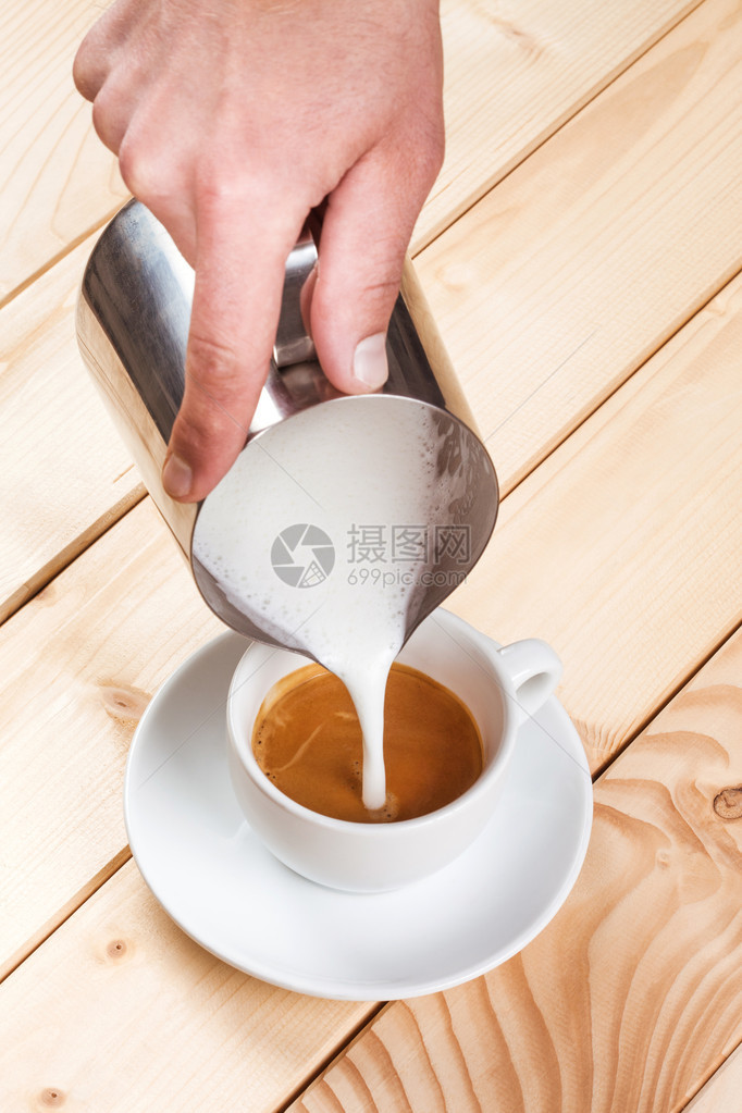 将起泡的牛奶倒入一杯咖啡中创造图案图片
