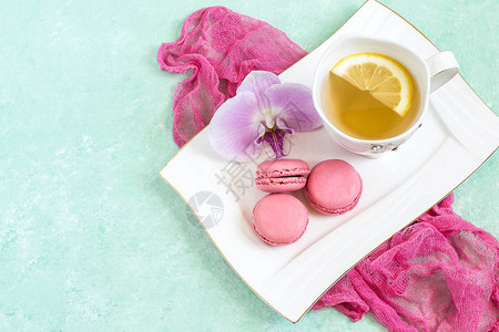 粉红蛋白杏仁饼干配草莓奶油兰花和白盘柠檬茶图片