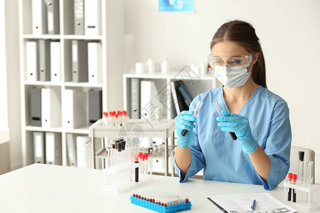 女医生在实验室餐桌上处理血样图片