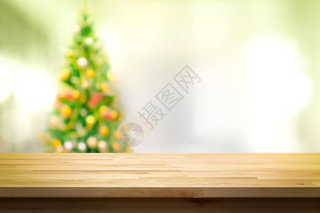 在模糊的圣诞树背景上的木板桌顶上图片