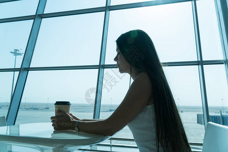 女孩在机场的商务休息室和飞机一起图片