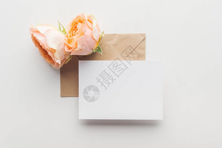 褐色信封和灰色背景粉红玫瑰上图片