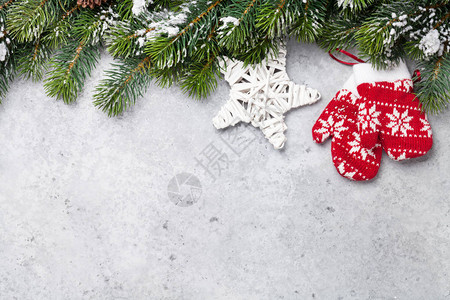 由雪和石本背景的装饰品所覆盖的圣诞fir树枝您的贺卡带有文字空间的X图片