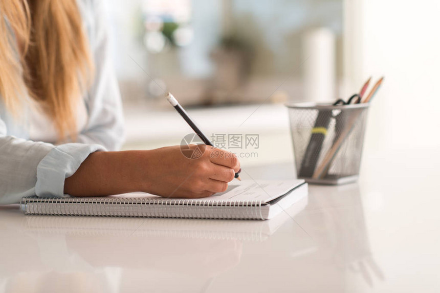 年轻美女在家学习时手写书图片