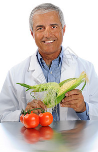 手持玉米耳朵的微笑科学家垂直格式在白色背景上方背景图片
