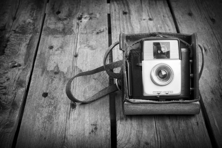 旧皮革案的旧相机用黑白木制背景背景图片