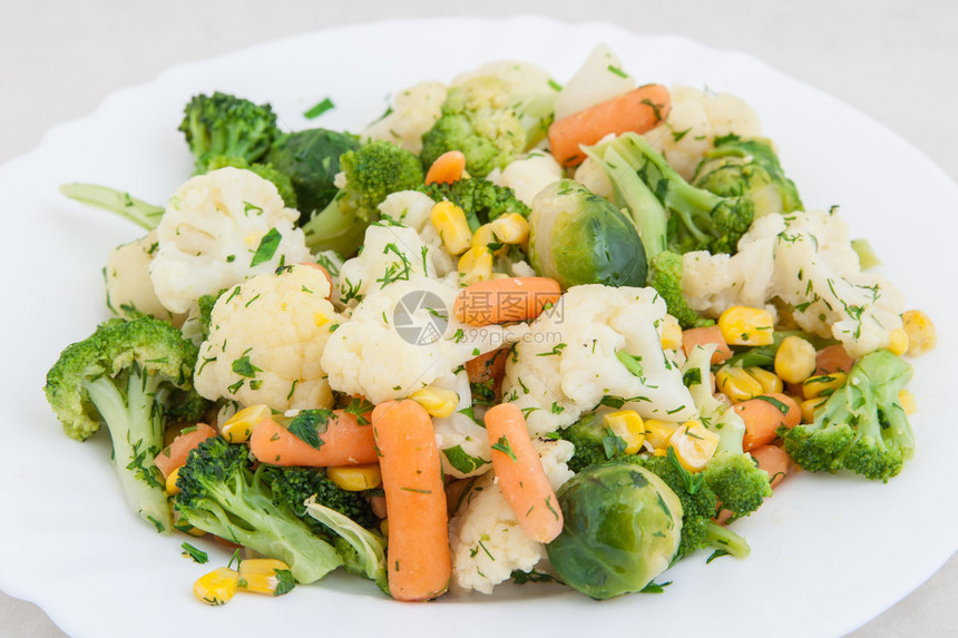 白盘中的熟蔬菜图片