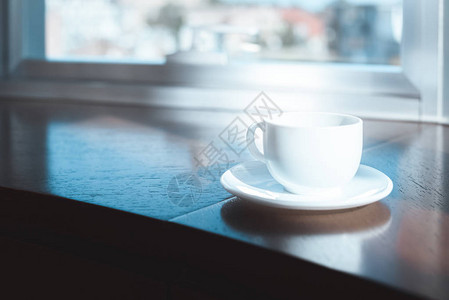 桌面上咖啡杯和碟子的特写视图图片