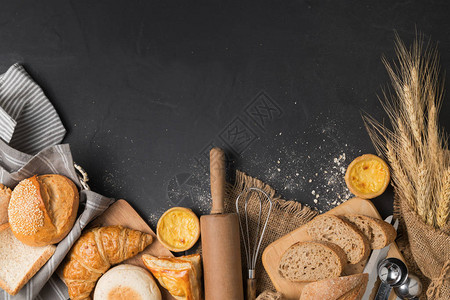 黑石背景上的面包和烘焙配料顶视图和输入文图片