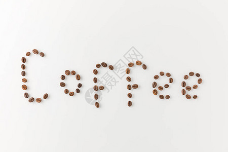 用白色隔离的咖啡豆制成的咖啡刻字背景图片
