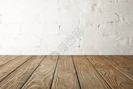 棕色木桌面和带砖的白墙背景图片