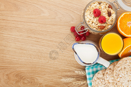 带梅斯利浆果和橙汁的卫生早餐从上方看木制餐桌图片