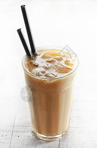 白色木桌上的一杯加牛奶的冰咖啡图片