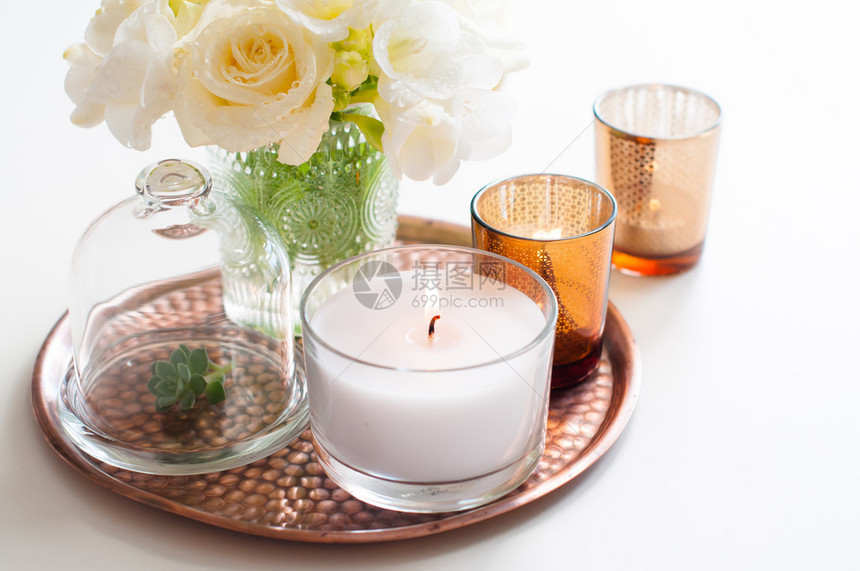 花瓶中的白花包铜托盘的蜡烛图片