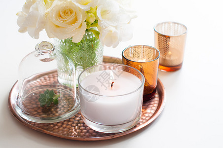 花瓶中的白花包铜托盘的蜡烛背景图片