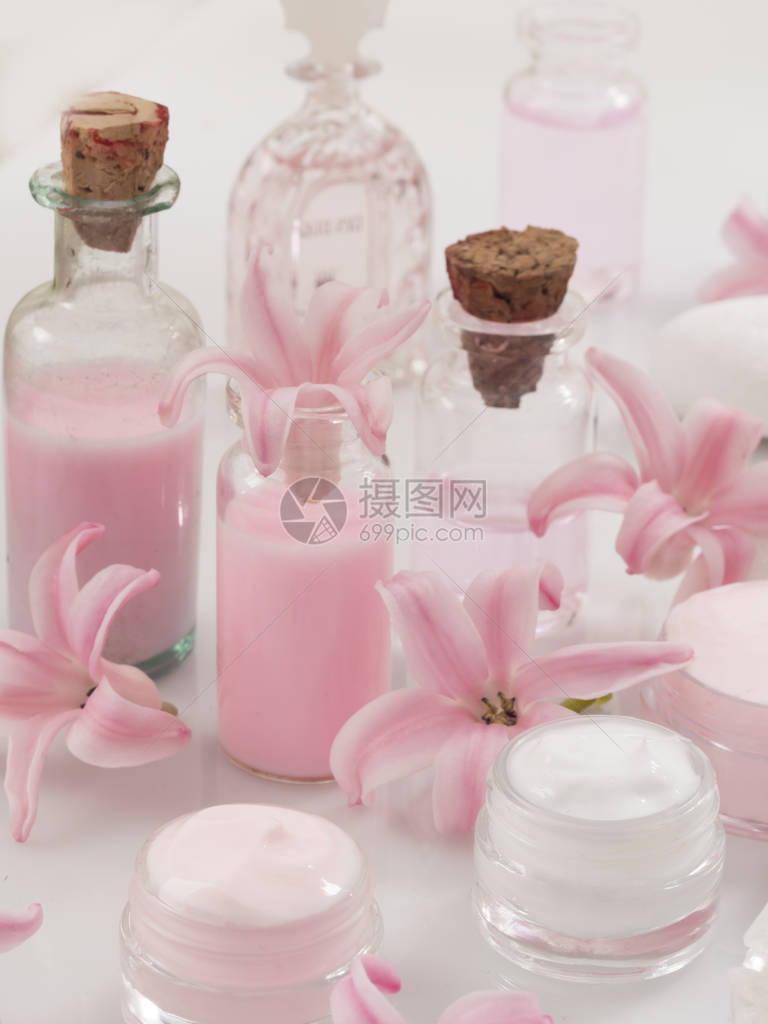 瓶装护肤品与粉色鲜花图片