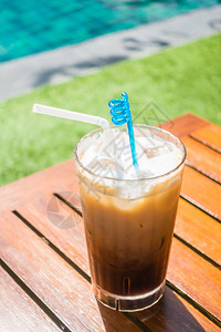 泳池景桌上的冰咖啡杯图片