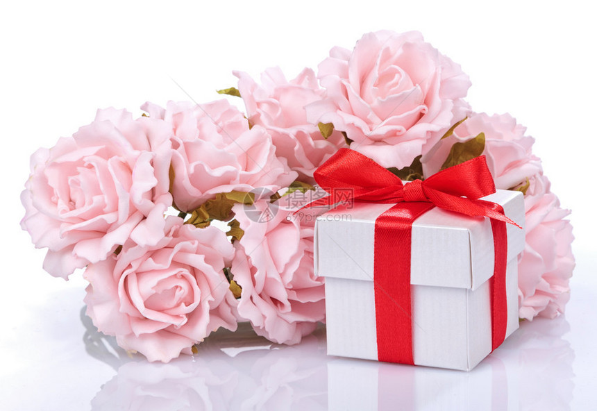 粉红鲜花和礼物盒带红色丝带在白图片