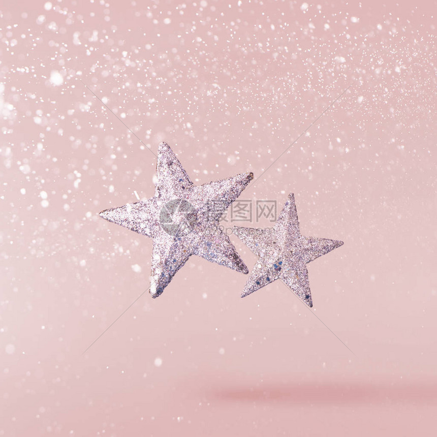 圣诞节的概念创意圣诞构想是在粉红色背景下坠入空中银星图片