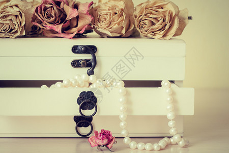 木制棺材中的白色珍珠项链与褪色的玫图片