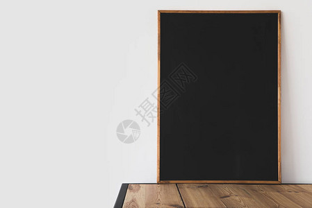 白色木桌上的一块大空黑板背景图片