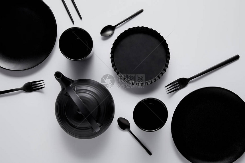 白色桌上黑茶壶板烘烤碗杯子勺子图片