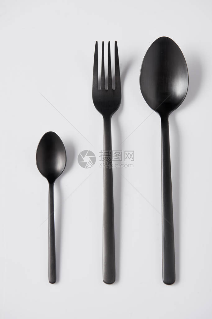 黑色勺子和叉子在白色背景最小化概图片