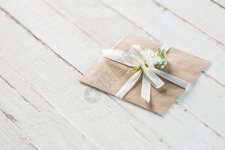 白色木制桌面上装有花和丝带邀请卡婚图片