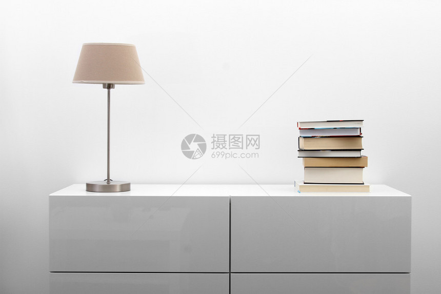 明亮的极简主义室内带灯和书籍的白色马桶图片
