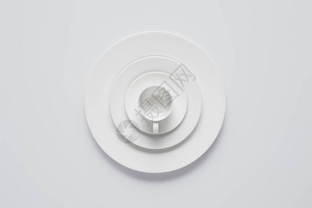 白色桌上不同牌盘和杯子排列的堆叠图示图片