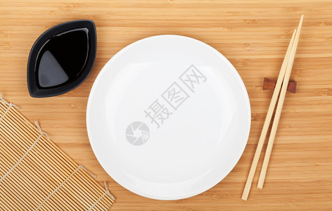 竹桌上的空盘子寿司筷子和酱油图片