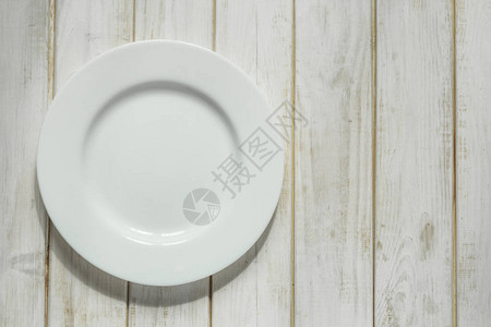 白色的空盘子放在白木桌上图片