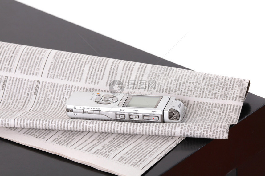 Diktafon和黑桌上的报纸在白色图片