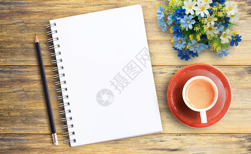 空白笔记本和木桌背景咖啡杯的图片