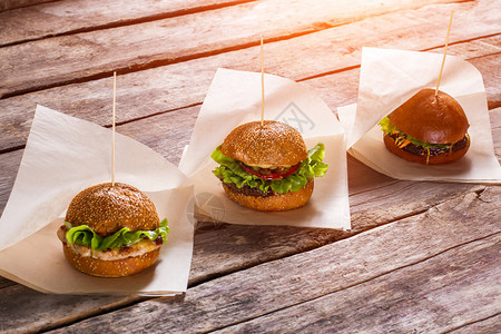 白色包装纸上的汉堡包旧木桌配汉堡多汁的生菜和热面包当地小酒图片
