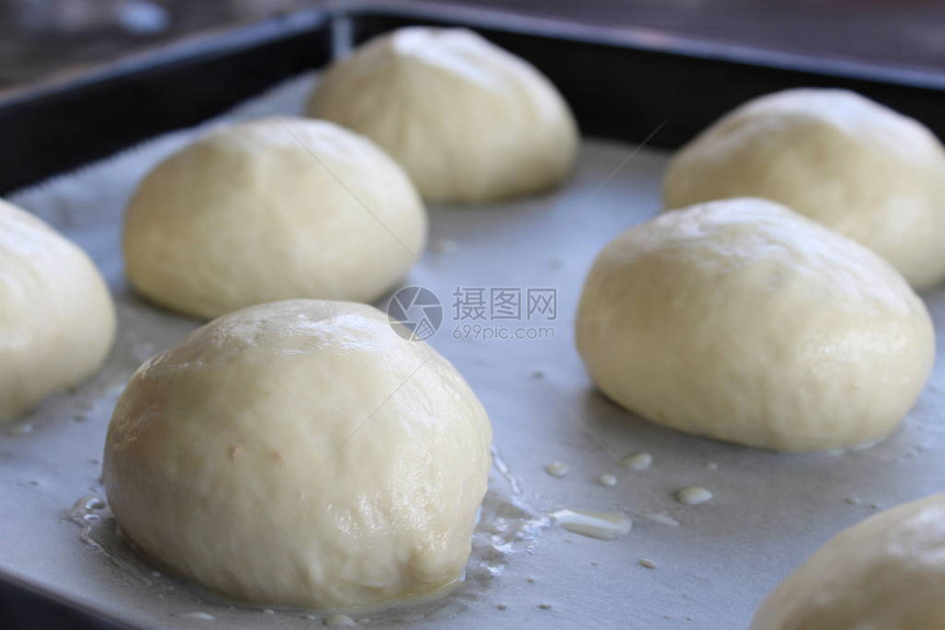 准备用烘烤纸在烤箱中烤自制复活节传统热十字面包自然日光图片